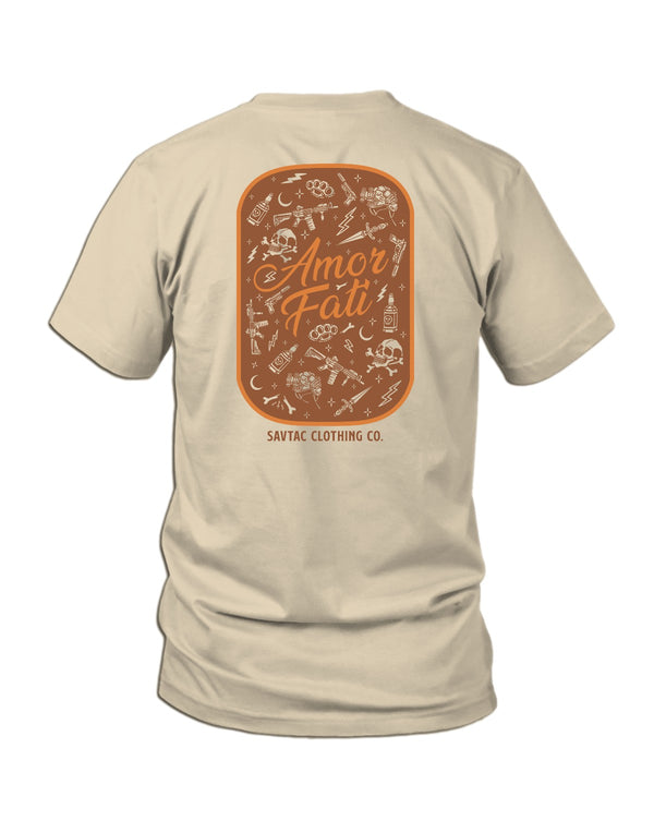 Savage Tacticians Tan tee featuring a rounded patch-style design packed with tactical icons (rifles, brass knuckles, skull and crossbones, whiskey bottle, knife, NVG helmet) surrounding script text "Amor Fati," "SavTac Clothing Co." below.