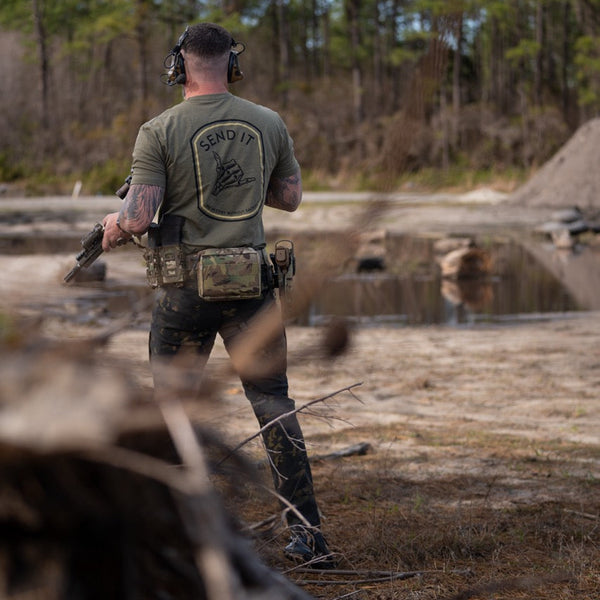 Man outdoors in tactical gear and Savage Tacticians 'Send It' shirt holding rifle