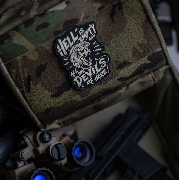 Savage Tacticians tactical patch with skull art on camo gear, night vision goggles nearby