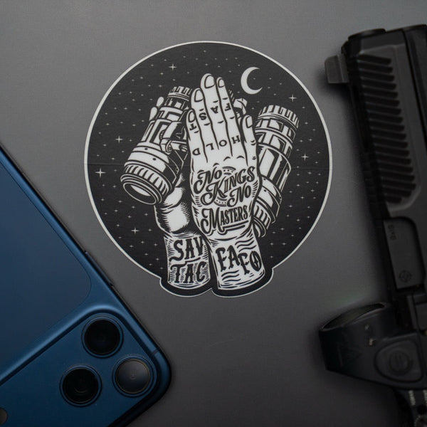 Savage Tacticians sticker featuring praying hands holding binoculars, beside a blue phone and handgun