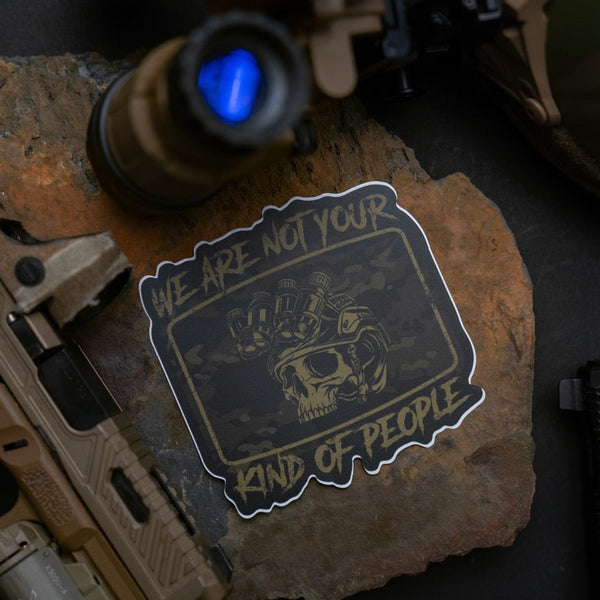 Savage Tacticians skull sticker with night vision goggles, tactical gear in background