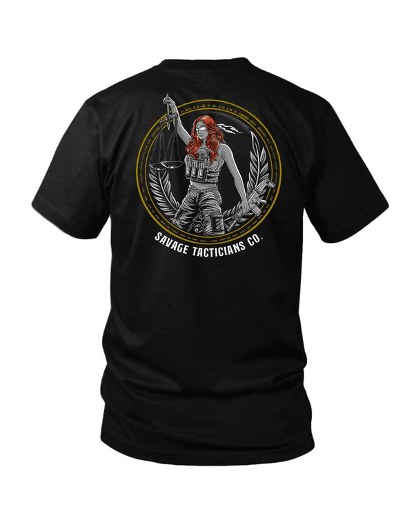 Savage Tacticians Black tee featuring a pin-up style Lady Justice with a blindfold, holding scales and a suppressed SMG, tactical plate carrier, laurel wreath border, text "Savage Tacticians Co."