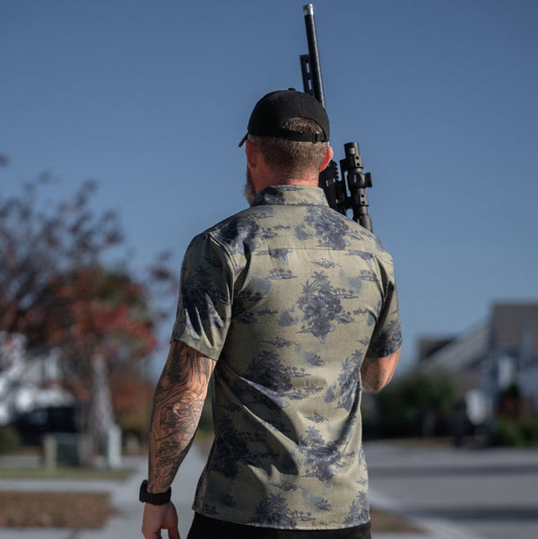 Savage Tacticians camo shirt with tropical print, man holding rifle outdoors