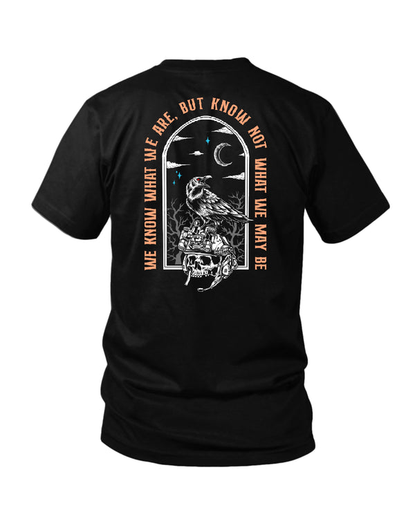 Savage Tacticians Black tee featuring a raven perched on a night-vision helmet resting on a skull inside a gothic arched window at night, arched text "We Know What We Are, But Know Not What We May Be."