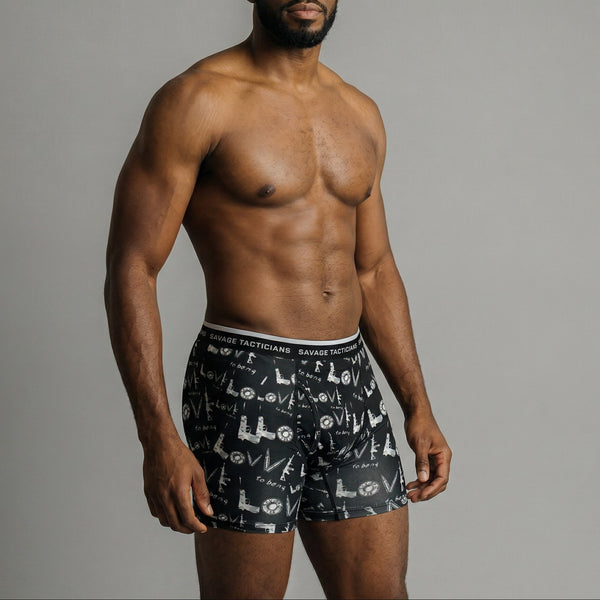 Male model wearing Savage Tacticians black graphic boxer briefs with bold waistband logo