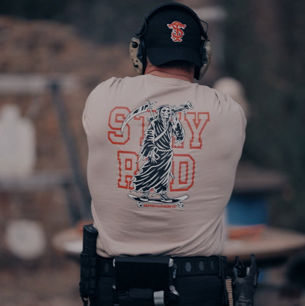 Savage Tacticians t-shirt with grim reaper graphic and 'STAY RAD' text, worn by person outdoors
