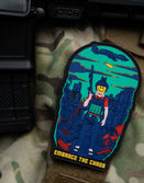 Savage Tacticians Embrace the Chaos patch on camouflage gear, featuring a smiley-face soldier.