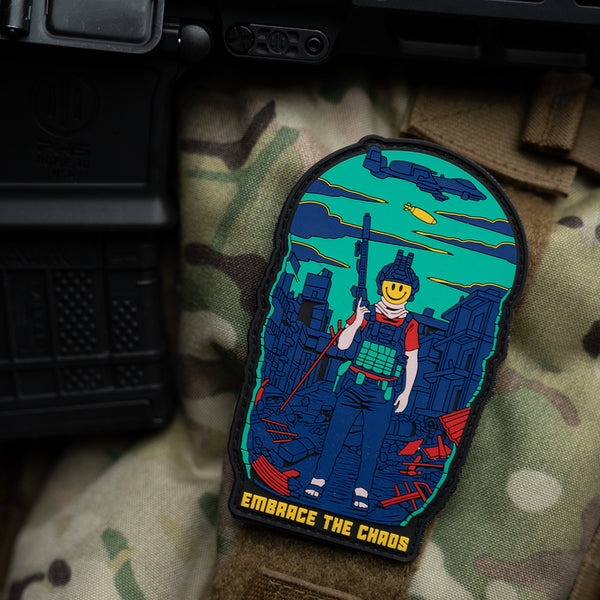 Savage Tacticians Embrace the Chaos patch on camouflage gear, featuring a smiley-face soldier.