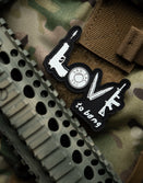 Savage Tacticians 'Love to Bang' morale patch on tactical gear and camouflage fabric