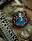 Savage Tacticians morale patch with grim reaper design on tactical vest, camo gear