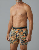 Man modeling Savage Tacticians camo boxer briefs with logo waistband on gray background
