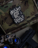 Savage Tacticians tactical patch with skull art on camo gear, night vision goggles nearby