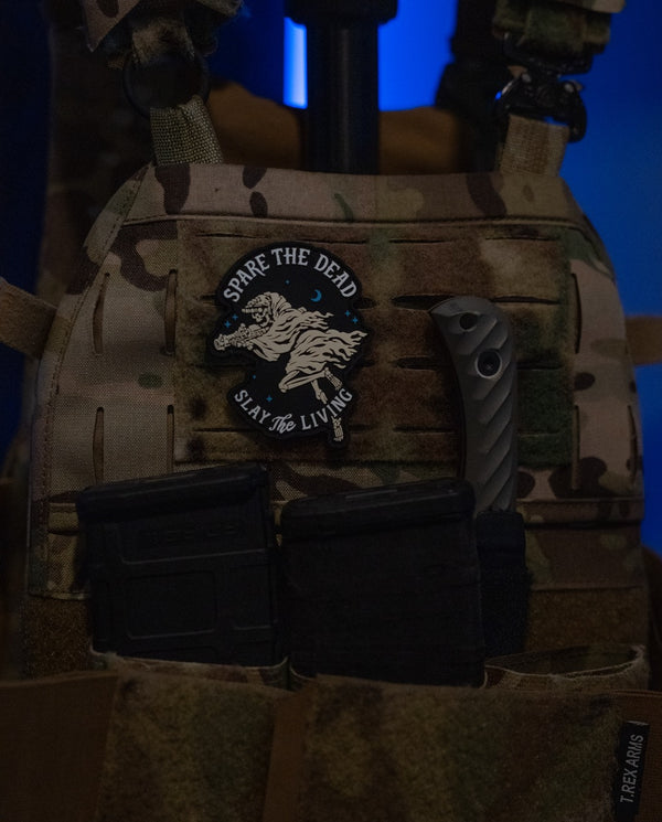 Savage Tacticians tactical vest with morale patch, knife, and magazine pouches in low light