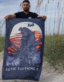 Man holding Savage Tacticians flag with samurai design and sunset background on beach