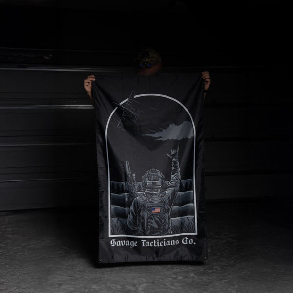 Person holding Savage Tacticians flag with soldier graphic and American flag patch