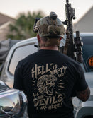 Man in tactical gear wearing Savage Tacticians shirt with bold graphic design and lettering