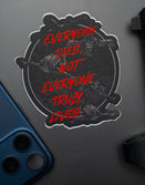 Savage Tacticians sticker with skull design and red text, placed by phone and firearm