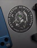Savage Tacticians sticker featuring tactical grim reaper with night vision, next to phone and handgun.