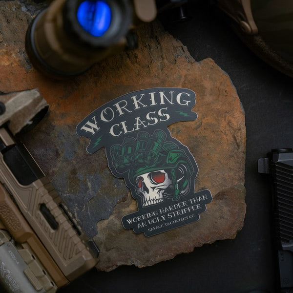 Savage Tacticians Working Class sticker with skull helmet on stone, tactical gear nearby