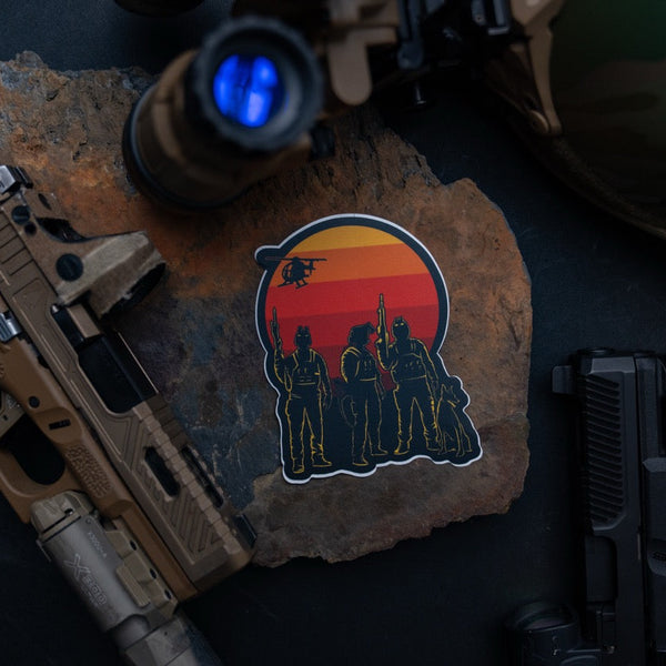 Savage Tacticians sticker with armed figures and sunset, surrounded by tactical gear