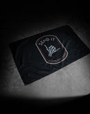 Savage Tacticians 'Send It' black flag with skeleton hand design on a concrete floor