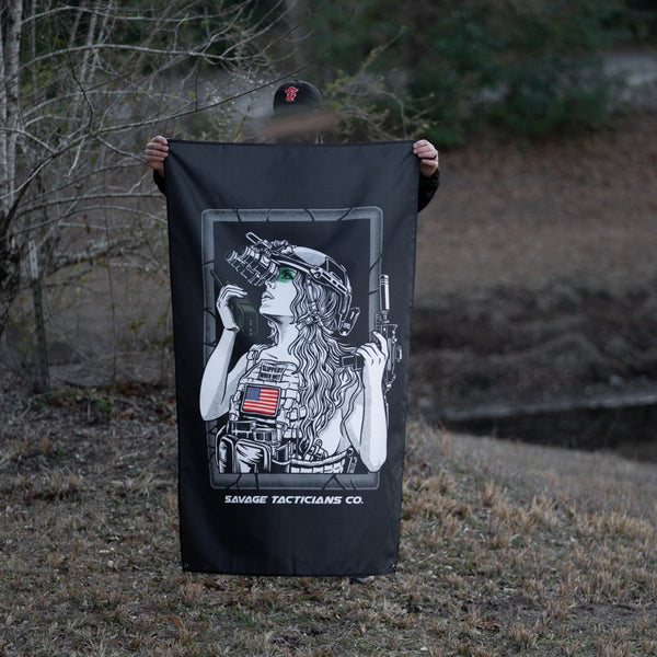 Person outdoors holding Savage Tacticians flag featuring tactical woman graphic with night vision