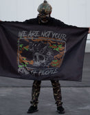 Person in tactical gear holding Savage Tacticians flag with skull graphic and camo design