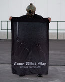 Person in tactical helmet holding Savage Tacticians 'Come What May' black flag outdoors