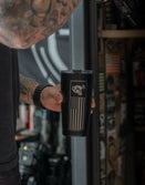 Tattooed man holding Savage Tacticians black tumbler with American flag and rhino design