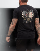 Man wearing Savage Tacticians black graphic t-shirt with military-themed back print