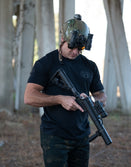 Person in tactical helmet with NODs wearing the Gangster tee holding a rifle in a urban setting