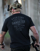 Model wearing the Gangsater tactical lifestyle shirt; premium lightweight black graphic tee with gritty military-inspired typography.