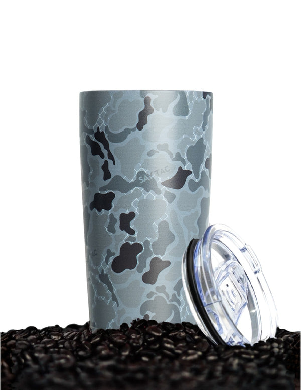 Savage Tacticians camo tumbler with clear lid on coffee beans