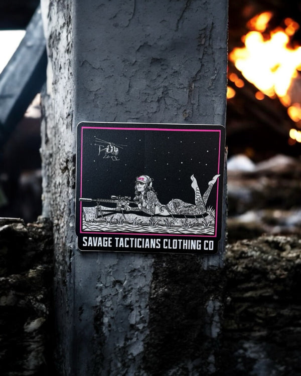 Savage Tacticians sticker with sniper graphic on concrete post, fire in background