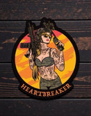 Savage Tacticians Heartbreaker patch with tattooed woman holding rifle and radio on wood background