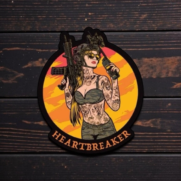 Savage Tacticians Heartbreaker patch with tattooed woman holding rifle and radio on wood background