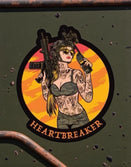 Savage Tacticians Heartbreaker sticker with tattooed woman holding rifle and radio