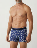 Man modeling blue Savage Tacticians boxer briefs with white airplane and palm print