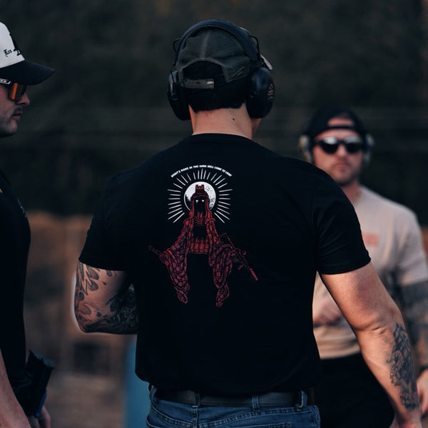Savage Tacticians black t-shirt with red graphic design, worn by man outdoors at range