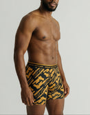 Male model wearing Savage Tacticians graphic boxer briefs with yellow and black pattern