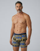 Man modeling Savage Tacticians blue and gold patterned boxer briefs, front view