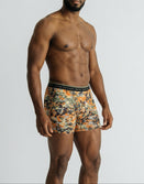 Man modeling Savage Tacticians camo boxer briefs with branded waistband on white background
